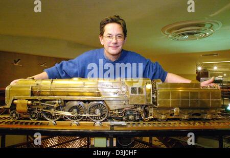 (Dpa) - Museumsdirektor Michel Glenat zeigt ein Messing-Modell einer britischen Dampfmaschine aus 1950, bewegliches Spielzeug und Modell-Bahn-Museum "Musee Anime du Jouet et des Petits Trains in Colmar, Frankreich, 9. Januar 2004. Das Modell misst 140 cm lang und wiegt 35 kg. Mit einem Knopf des Motors kann eingeschaltet werden und startet seine Räder bewegen und laufen entlang der Gleise. Stockfoto