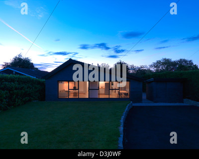 Hollins Lane, Marple Bridge, Großbritannien. Architekt: Roz Barr Architekten, 2012. Wichtigsten Elevation, Dämmerung. Stockfoto