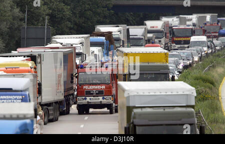 (Dpa) - Feuerwehrfahrzeuge kämpfen sich ihren Weg in die Szene des Unfalls auf der Inntal-Autobahn in der Nähe von Reischenhart, Deutschland, 18. Juli 2005. Trotz eines brennenden LKW hat folgende Fahrzeuge keine Gasse für Rettungsfahrzeuge und erschwert dadurch die Zuordnung der Feuerwehr und des Roten Kreuzes. Foto: Matthias Schrader Stockfoto