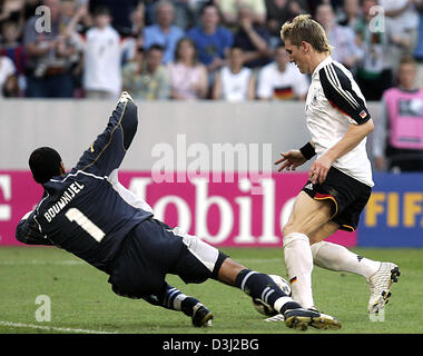 (Dpa) - deutscher Fußballspieler Bastian Schweinsteiger (R) spielt den Ball vorbei an Tunesien Torwart Ali Boumnijel während der Gruppe eine Übereinstimmung des Confederations Cup Turnier Tunesien Vs Deutschland in Köln, Deutschland, 18. Juni 2005. Deutschland gewann das Spiel durch eine Kerbe von 3: 0. Stockfoto