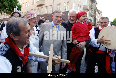 (Dpa) - German President Horst Koehler (C), seine Frau Eva (L) und Peter Harry Carstensen (R) der CDU und Premier des Landes Schleswig-Holstein werden von der italienischen folk-Gruppe "Eco de Gargano" in Kiel, Deutschland, 18. Juni 2005 begrüßt werden. Stockfoto