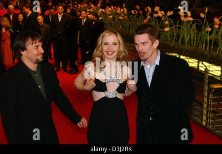 (Dpa) US-Schauspielerin Julie Delpy passt ihr Oberteil als ihr Kollege Ethan Hawke (rechts) und ihre Anmerkungen Regisseurs Richard Linklater Flüstern, als sie den roten Teppich der Berlinale-Kino am 10. Februar 2004 in Berlin Fuß. Die US-Stars kamen zur Premiere ihres Films "Before Sunset", die während der 54. Berlinale Fim Festival gezeigt wurde, die bis zum 15. Februar läuft. Stockfoto