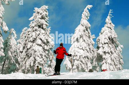 (Dpa) - Ski ein Skifahrer unter blauem Himmel durch eine verschneite Landschaft auf dem Wurmberg einen 965 Meter hohen Berg in Braunlage, Deutschland, 29. Januar 2004. Schnee und sonnig werden voraussichtlich in den nächsten Tagen das Wetter in Deutschland dominieren. Stockfoto