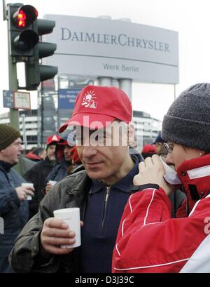 (Dpa)-Arbeiter trinken heißen Tee Tassen während einer Kundgebung im DaimlerChrysler-Werk in Berlin 29. Januar 2004. Deutschlands leistungsstarke Metalworkers Union IG Metall begann eine Welle von Streiks Warnung frühen Donnerstagmorgen seine Wanderung Lohnforderungen zu drücken. Tausende von Arbeitern beendet Arbeit kurz nach Mitternacht bei Pflanzen, die DaimlerChrysler, Bosch-Elektronik, Epcos, Infineon, Osram und Contin enthalten Stockfoto