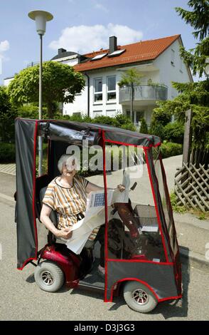 (Dpa-Dateien) - treibt die 83 jährige Margarethe Strobel arbeitet als ein Haus-Sitter von Haus zu Haus in ihrem Elektro-Trolley in Welzheim, Deutschland, 3. Juni 2003. Sie setzt die Häuser der Menschen, die auf Reisen oder im Ausland zu arbeiten. Zu ihren Aufgaben gehören die Fütterung der Tiere, den Briefkasten leeren und die Blumen gießen. Stockfoto