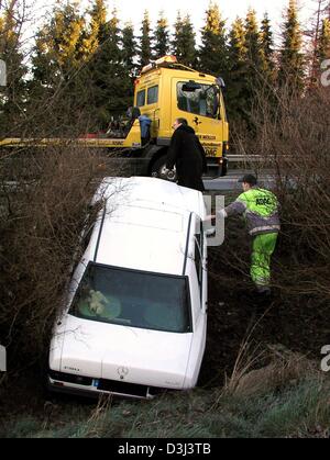 (Dpa) - ein Service-Truck des deutschen Automobilclub ADAC, steht auf der Straße über einen Mercedes, in einem kleinen Hang auf der Seite in Bordesholm, Deutschland, 12. Dezember 2003 gefangen ist. Regen hatte vorraus glasiert Frost verursachen, auf der Straße. Gräben entlang Landstraßen haben zahlreiche Fahrer mit ihren Autos endete. Mehr als 300 Fälle von verglasten Frost bezogene waren Unfälle Stockfoto