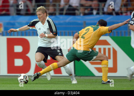 (Dpa) - deutsche Fußballer Bastian Schweinsteiger (L) kämpft um den Ball mit australischen Spieler Kevin Muscat während das Eröffnungsspiel der FIFA Confederations Cup Deutschland Vs Australien in Frankfurt am Main, 15. Juni 2005. Stockfoto