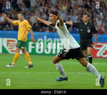 (Dpa) - deutscher Fußballspieler Kevin Kuranyi feiert sein Tor, während Australier Brett Emerton (L) während das Eröffnungsspiel der FIFA Confederations Cup Deutschland Vs Australien in Frankfurt am Main, 15. Juni 2005 sucht auf. Stockfoto