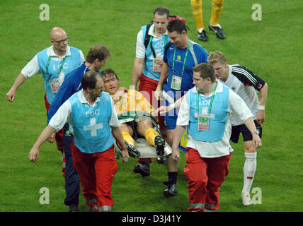 (Dpa) - Fußball Spieler Bastian Schweinsteiger (R) Gesten während des australischen Spieler Josip Skoko (C) durch Krankenwagen Männer während der Eröffnung erfolgt des FIFA Confederations Cup Deutschland Vs Australien in Frankfurt am Main, 15. Juni 2005 entsprechen. Stockfoto