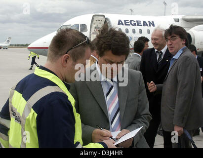 (Dpa) - deutscher Trainer der griechischen Fußball-Nationalmannschaft, Otto Rehhagel (C), unterschreibt ein Autogramm, ein Fan nach seiner Ankunft auf dem Flughafen Leipzig/Halle, Deutschland, 11. Juni 2005. European Football Champion Griechenland bewegt sich bis zu Gesicht World Champion Brasilien in den Konföderationen-Pokal am Zentralstadion in Leipzig, Deutschland am 16. Juni. Stockfoto