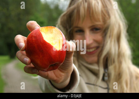 (Dpa-Datei) - das Bild vom 6. Mai 2005, zeigt eine junge Frau, nachdem er in einen Apfel in Gescher, Deutschland gebissen. Stockfoto