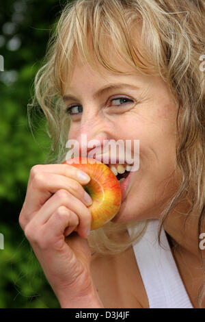 (Dpa-Datei) - das Bild vom 6. Mai 2005, zeigt eine junge Frau Essen eines Apfels in Gescher, Deutschland. Stockfoto