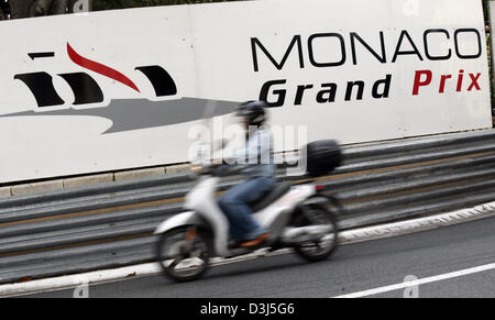 (Dpa) - fährt ein Motorrad vor eine Werbetafel für den Grand Prix von Monaco in Monte Carlo, Monaco, 18. Mai 2005. Stockfoto