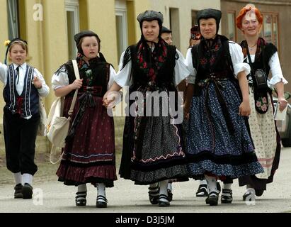 (Dpa) - eine Gruppe von Kindern, gekleidet in traditionellen Kostümen, zu Fuß entlang einer Straße auf dem Weg zur Eröffnung des 1. deutschen Tracht-Festival für Kinder und Jugendliche in Wechmar, Deutschland, 28. Mai 2004. Stockfoto