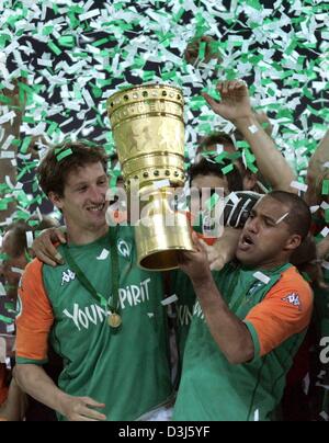 (Dpa) - Bremen Kapitän Frank Baumann (L) und sein brasilianischer Teamkollege Ailton (R) erhöhen den DFB-Pokal (deutscher Fußball Bund Cup) vor ihren jubilierende Teamkollegen. Deutsche Liga Meister Werder Bremen gewinnt die 61. DFB-Pokalfinale gegen Erstligisten club Alemannia Aachen im Olympiastadion in Berlin, Deutschland, 29. Mai 2004 mit einem Score von 3: 2. Bremen gewann den Cup zum fünften Stockfoto