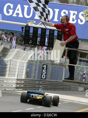 (Dpa) - Geschwindigkeiten italienische Formel 1 pilot Jarno Trulli (R) mit seinem Renault Formel 1 Rennwagen durch die Ziellinie in der Formel 1 Grand Prix von Monaco, 23. Mai 2004. Trulli gewann den Grand Prix von Monaco und feierte den ersten Sieg in seiner Karriere. Stockfoto