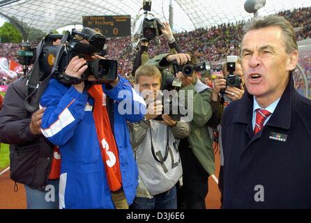 (Dpa) - Bayern Fußball-Trainer Ottmar Hitzfeld (R) steht vor einer Gruppe von Journalisten und Fotografen nach der Bundesliga-Fußball-Spiel gegen FC Bayern München und SC Freiburg im Olympiastadion in München, 22. Mai 2004. Hitzfeld wird Bayern München nach sechs Jahren als der Club Fußball Trainer verlassen. Stockfoto