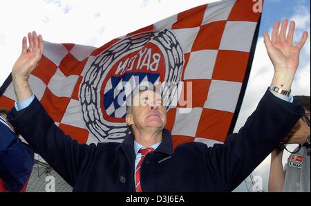 (Dpa) - Bayern Fußball-Trainer Ottmar Hitzfeld cheers und jubilates vor dem Club Flagge nach dem Bundesliga-Fußball-Spiel gegen FC Bayern München und SC Freiburg in München, 22. Mai 2004.  Hitzfeld wird Bayern München nach sechs Jahren als der Club Fußball Trainer verlassen. Stockfoto