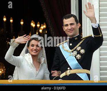 (Dpa) - spanische Kronprinz Felipe und seine Frau Letizia Ortiz Lächeln und winken Hände, wie sie auf dem Balkon des königlichen Palastes nach ihrer Hochzeit am Almudena-Kathedrale in Madrid, Spanien, 22. Mai 2004 stehen. Stockfoto