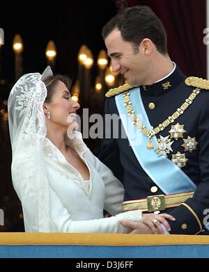 (Dpa) - spanische Kronprinz Felipe und seine Frau Letizia Ortiz an den Händen halten und schauen einander mit einem Lächeln, als sie auf dem Balkon des königlichen Palastes nach ihrer Hochzeit am Almudena-Kathedrale in Madrid, Spanien, 22. Mai 2004 stehen. Stockfoto