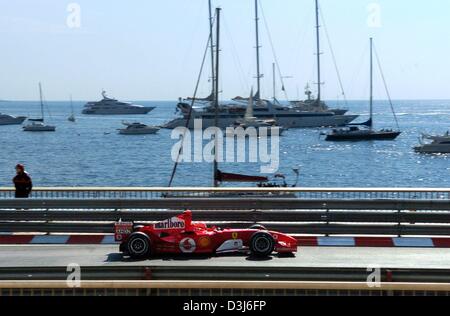 (Dpa) - deutsche Formel 1 pilot und Weltmeister Michael Schumacher steuert seine Ferrari-Rennwagen während des freien Trainings an der Stadt-Strecke vorbei an den beeindruckenden Backrop von der Cote D' Azur in Monaco, Donnerstag, 20. Mai 2004. Schumacher fuhr die schnellste Zeit. Die Formel 1 Grand Prix von Monaco wird am Sonntag, 23. Mai 2004 stattfinden. Stockfoto