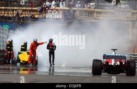 (Dpa) - australische Formel 1 pilot Mark Webber (C) Weg von geht glimmenden ist Jaguar Rennwagen während des freien Trainings auf dem Stadtkurs in Monaco, Donnerstag, 20. Mai 2004. Webbers Rennwagen erlitten einen Motorschaden und fing Feuer. Die Formel 1 Grand Prix von Monaco wird am Sonntag, 23. Mai 2004 stattfinden. Stockfoto