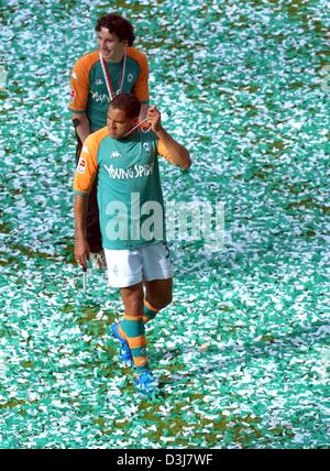 (Dpa) - Bremens brasilianische vorwärts Ailton (vorne) verlässt die Konfetti-bedeckten Tonhöhe nach der Bundesliga Fußball-Spiel gegen SV Werder Bremen und Bayer 04 Leverkusen in Bremen, Deutschland, 15. Mai 2004. Bremen hatte bereits gesichert, die 2003/2004 Deutscher Meister Titel in der Fußball-Spiel gegen FC Bayern München zwei Tage vor dem Ende der Bundesliga-Saison. Stockfoto