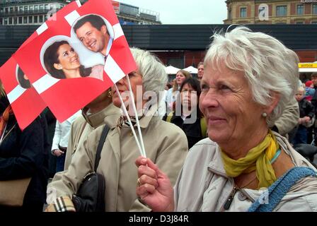 (Dpa) - eine ältere Dame Wellen dänische Fahnen mit Bildern von Kronprinz Frederik und seine Verlobte Mary Donaldson als die königliche Hochzeit paar Posen auf dem Balkon des Rathauses in Kopenhagen, 12. Mai 2004. Die dänische Hauptstadt ist immer bereit für die königliche Hochzeit von Kronprinz Frederik in Kopenhagen Kathedrale auf Freitag, 14. Mai 2004 stattfinden wird. Stockfoto