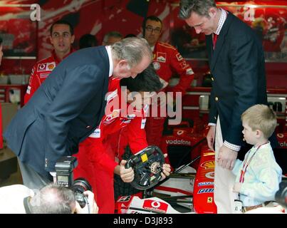 (Dpa) - spanische König Juan Carlos (L) untersucht zusammen mit Mitgliedern seiner Familie Inaki Urdangarin (R), Ehemann von Infantin Cristina und ihr Sohn Juan Valentin (vorne, R), einen Formel 1 Rennwagen auf Ferrari Pit vor Start des spanischen Grand Prix in der Formel 1 Rennstrecke in Barcelona, Spanien, 9. Mai 2004. Stockfoto