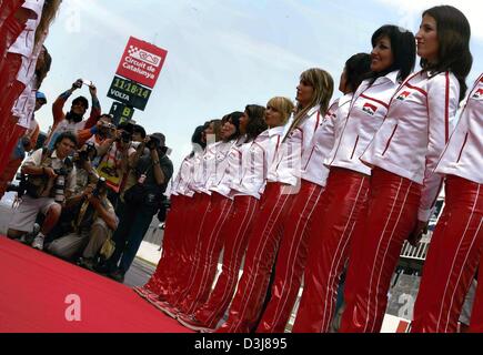 (Dpa) - eine Reihe von Grid Girls Line-up neben einem roten Teppich während eine Gruppe von Fotografen (L) fotografieren vor Beginn des Grand Prix von Spanien in der Formel 1 Rennstrecke in Barcelona, Spanien, 9. Mai 2004. Stockfoto