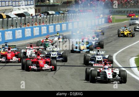 (Dpa) - britische Formel 1 pilot Jenson Button (R) (BAR-Honda) und deutsche Formel 1 pilot und Welt champion Michael Schumacher (L) (Ferrari) führen das Feld der Rennwagen zu Beginn des grand Prix von San Marino in Imola, Italien, 25. April 2004. Schumacher gewann das Rennen vor Button und kolumbianische Formel 1 pilot Montoya (BMW-Williams). Stockfoto