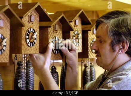 (Dpa) - Feinmechaniker Uwe Bergmann mit einem Stethoskop untersucht die Zeit einer Kuckucksuhr bei einem Uhrmacher in Gernrode, Ostdeutschland, 15. März 2004. Obwohl die Kuckucksuhr ein typisches Souvenir aus dem Schwarzwald in Süddeutschland ist, hat die Herstellung von Kuckucksuhren eine Tradition in Gernrode seit Jahrzehnten. Stockfoto