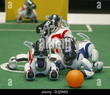 (Dpa) - Teams "Aibo" Roboter von Sony, kämpfen um den Ball während der "German Open" des Robocup 2004-Fußball-Roboter-Wettbewerb in Paderborn, Deutschland, 2. April 2004. Vier "Aibo" Roboter bilden ein Team. Mehr als 150 Teams aus 13 Ländern nehmen an der Veranstaltung teil. Stockfoto