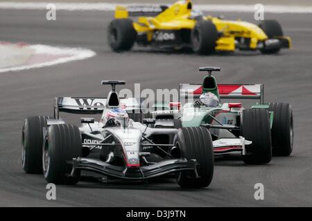 (Dpa) - finnische Formel 1 pilot Kimi Raeikkoenen (McLaren-Mercedes, vorne) Österreichs Christian Klien (Jaguar) während der Formel 1 Grand Prix in Manama, Bahrain, 4. April 2004 überholt. Stockfoto