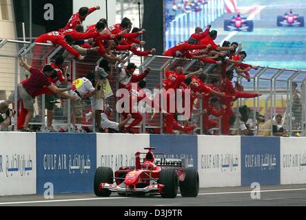 (Dpa) - das Ferrari Team Prost als deutsche Formel 1 pilot Michael Schumacher in Manama, Bahrain, 4. April 2004 gewinnt. Michael Schumacher gewann den ersten jemals Formel 1 Grand Prix von Bahrain und seinem 73. insgesamt, und erweitert seine Führung in der Fahrerwertung mit einem perfekten drei von drei für die Saison gewinnt. Stockfoto