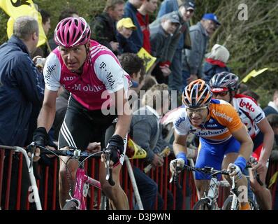 (Dpa) - deutsche Radfahrer Jan Schaffrath (L) von T-Mobile Team reitet auf seinem Fahrrad bergauf, dicht gefolgt von niederländischen Radrennfahrer Steven de Jongh von Team Rabobank, vorbei an einer jubelnden Menge von Zuschauern bei der Flandern-Rundfahrt, das zweite Rennen der World Cup Serie, in der Nähe von Meerbecke, Belgien, 4. April 2004. Das Rennen umfasst eine Strecke von 257 km. Stockfoto