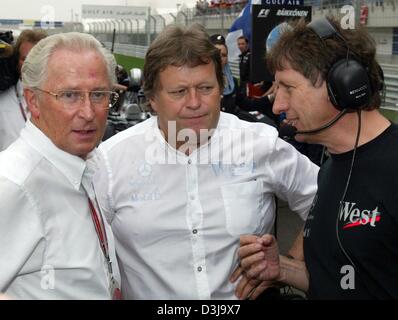 (Dpa) - Jürgen Hubberth (L), Vorsitzender der Mercedes-Benz, Norbert Haug, Leiter des Mercedes Motorsport und Mario Illien, Leiter Engineering, sprechen miteinander in der Formel 1 Rennstrecke in Manama, Bahrain, 4. April 2004. Stockfoto