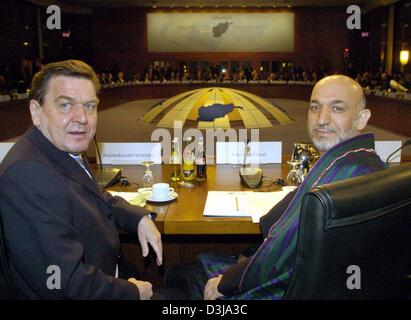 (Dpa) - deutsche Bundeskanzler Gerhard Schröder (L) und afghanischen Präsidenten Hamid Karzai wenden sich an den Fotografen zu Beginn der Afghanistan-Konferenz in Berlin, auf Mittwoch, 31. März 2004. Im Rahmen der Konferenz diskutieren Politiker aus 56 Staaten den Wiederaufbau des vom Krieg zerrissenen Land und finanzielle Hilfen. Stockfoto