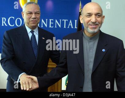 (Dpa) - US-Außenminister Colin Powell (L) und der afghanische Präsident Hamid Karzai Hände schütteln am Rande der Afghanistan-Konferenz in Berlin am Mittwoch, 31. März 2004. Auf der zweitägigen Konferenz Politiker aus 56 Staaten diskutieren über den Wiederaufbau des vom Krieg zerrissenen Land und finanzielle Hilfen. Stockfoto