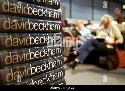 (Dpa) - Visitors (R) sitzen neben einem Haufen von Buch von britischen Fußballer David Beckham auf der Leipziger Buchmesse in Leipzig, Deutschland, 26. März 2004. Random-House-Verlag veröffentlicht die Autobiografie von Fußballstar David Beckham die befasst sich mit dem turbulenten Leben und die dunkle Seite des Ruhms. Stockfoto