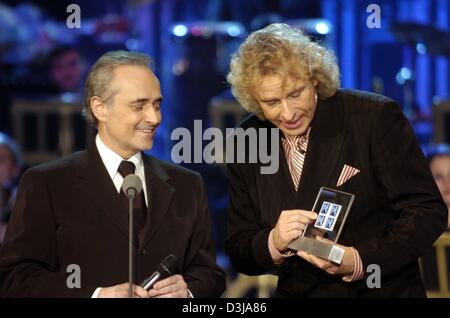 (Dpa) Deutsche TV-Moderator Thomas Gottschalk zeigt österreichische Briefmarken mit dem Bild von Jose Carreras, der spanische Tenor sich im deutschen TV show "Wetten dass...?" (Wetten, dass...?), in Basel, Schweiz am Samstag, 27. März 2004. Stockfoto