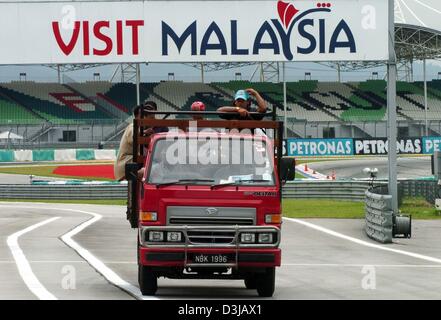 (Dpa) Malaysische Arbeitnehmer sind auf der Zielgeraden der Sepang Rennstrecke in der Nähe von Kuala Lumpur auf Mittwoch, 17. März 2004 transportiert. Auf Sonntag, 21. März 2004 wird der Grand Prix von Malaysia im Gange. Stockfoto