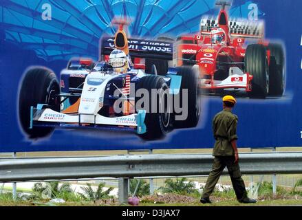 Ein malaysischer Soldat geht vorbei an einer Plakatwand in der Nähe der Sepang Rennstrecke in der Nähe von Kuala Lumpur auf Mittwoch, 17. März 2004. Auf Sonntag, 21. März 2004 wird der Grand Prix von Malaysia im Gange. Stockfoto