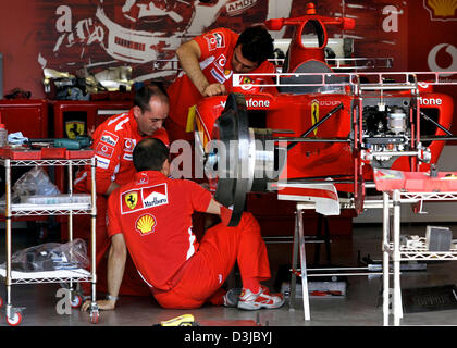 (Dpa) - Grube Mechanik des Ferrari-Team-Arbeit auf den Rennwagen der deutsche Formel1 Rennfahrer Michael Schumacher im Ferrari auf der Nürburgring Formel1 Rennstrecke in Nuerburg, Deutschland, 26. Mai 2005. Der Grand Prix von Europa findet auf dem Nürburgring am Sonntag, 29. Mai 2005. Stockfoto