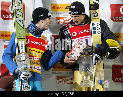 (Dpa) - spricht finnischer Skispringer Janne Ahonen (L) mit österreichischen Martin Höllwarth während der 53. internationalen Vierschanzentournee in Bischofshofen, Österreich, 6. Januar 2005. Höllwarth gewann die letzte Etappe der Skisprung-vier Hügel-Tour und Gesamtsieger Janne Ahonen eine seltene Grand-Slam-verweigert. Stockfoto