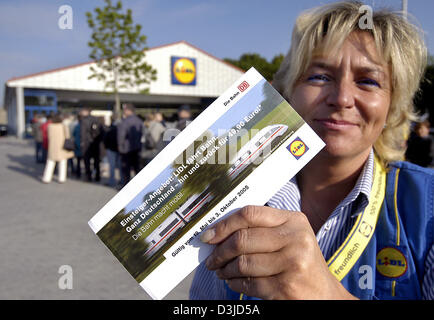 (Dpa) - Sales Assistant Ramona Wienholz präsentiert ein Zugticket, wie sie stehen vor einer Filiale der deutsche Discounter Lidl in Augsburg, Deutschland, Donnerstag, 19. Mai 2005. Eine Gruppe von Kunden Schlange vor dem Eingang.  Lidl-Läden verkaufen jetzt Bahntickets zum ersten Mal. In einigen Filialen des Unternehmens ging die Tickets innerhalb von Minuten ausverkauft. Stockfoto