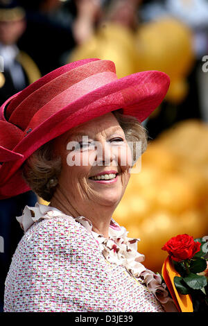 (Dpa) - Königin Beatrix der Niederlande trägt einen roten Hut und lächelt, als sie eine rote rose in der Hand in der Seasside Badeort Scheveningen, Deutschland, 30. April 2005 hält. Die Königin und ihre Familie feierte gemeinsam mit dem Publikum ihr 25. Jubiläum. Stockfoto