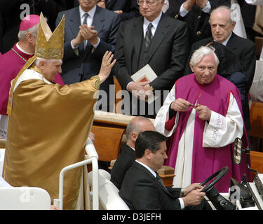 (Dpa) - Papst Benedict XVI (Lt) lächelt und winkt als er reitet auf der sogenannten "Papamobile" durch die Menge, die Weitergabe seines Bruders Georg Ratzinger (R) Square St. Peter im Vatikan in Rom, 24. April 2005. Papst Benedict XVI als neuen Leiterin der römisch-katholischen Kirche, heute am Sonntag, 24. April 2005 eingeweiht. Rund 100.000 Menschen nahmen an der Veranstaltung teil. Stockfoto