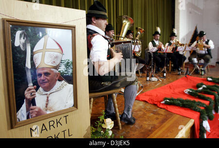 (Dpa) - eine traditionelle bayerische Blasmusik spielt auf der Bühne neben einem Bild (L) von der neugewählte Papst Benedikt XVI. in Marktl am Inn, Deutschland, 19. April 2005. Kardinal Joseph Ratzinger, geboren in Marktl am Inn, neue Papst Benedikt XVI., der erste deutsche Papst in den letzten 480 Jahren gewählt wurde. Stockfoto