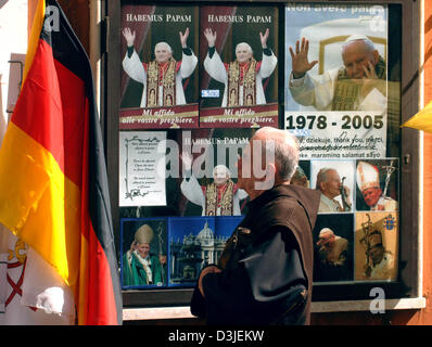 (Dpa) - geht ein Monch Plakate und Bilder von den neuen Papst Benedict XVI und den verstorbenen Papst Johannes Paul II auf dem Display an einen Souvenir-Shop in Rom, Italien, Freitag, 22. April 2005. Feierliche Einweihung des neuen Papst Benedict XVI wird vor der Basilika St. Peter am Sonntag, 24. April 2005 stattfinden. Stockfoto